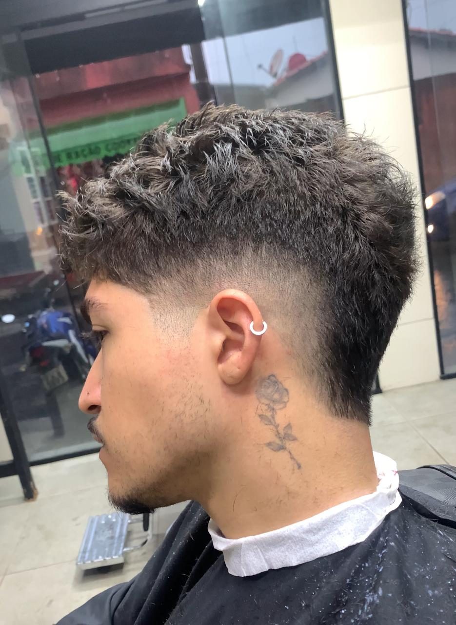 Corte moicano cacheado com desenho na navalha, realizado na Los Henrique's